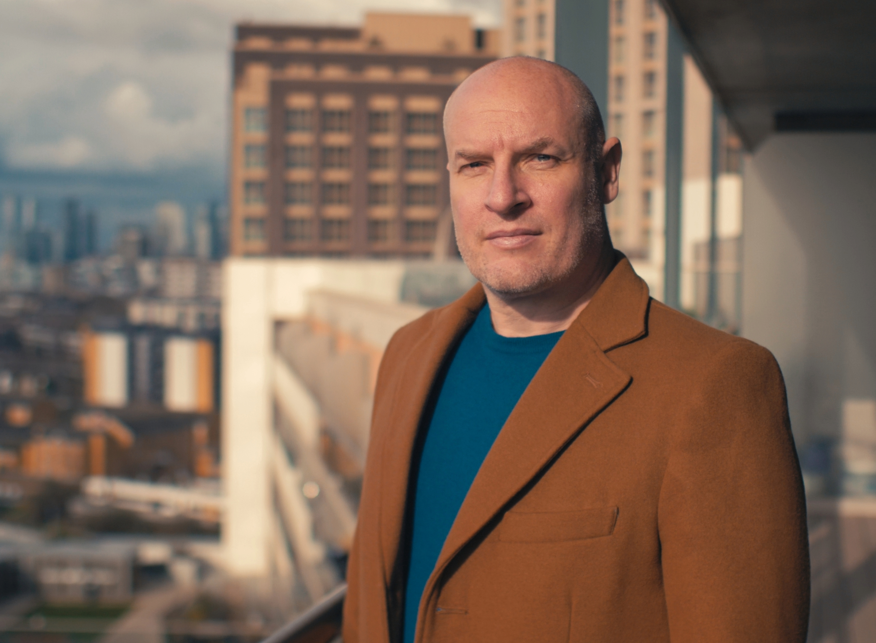 Alex Thomas - Looking professional and serious looking at the camera on a balcony